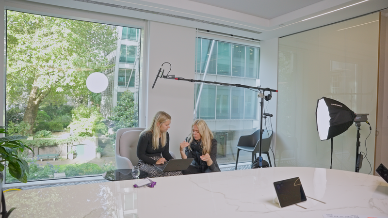 two females  with long hair talking through a script for a corporate video production shoot